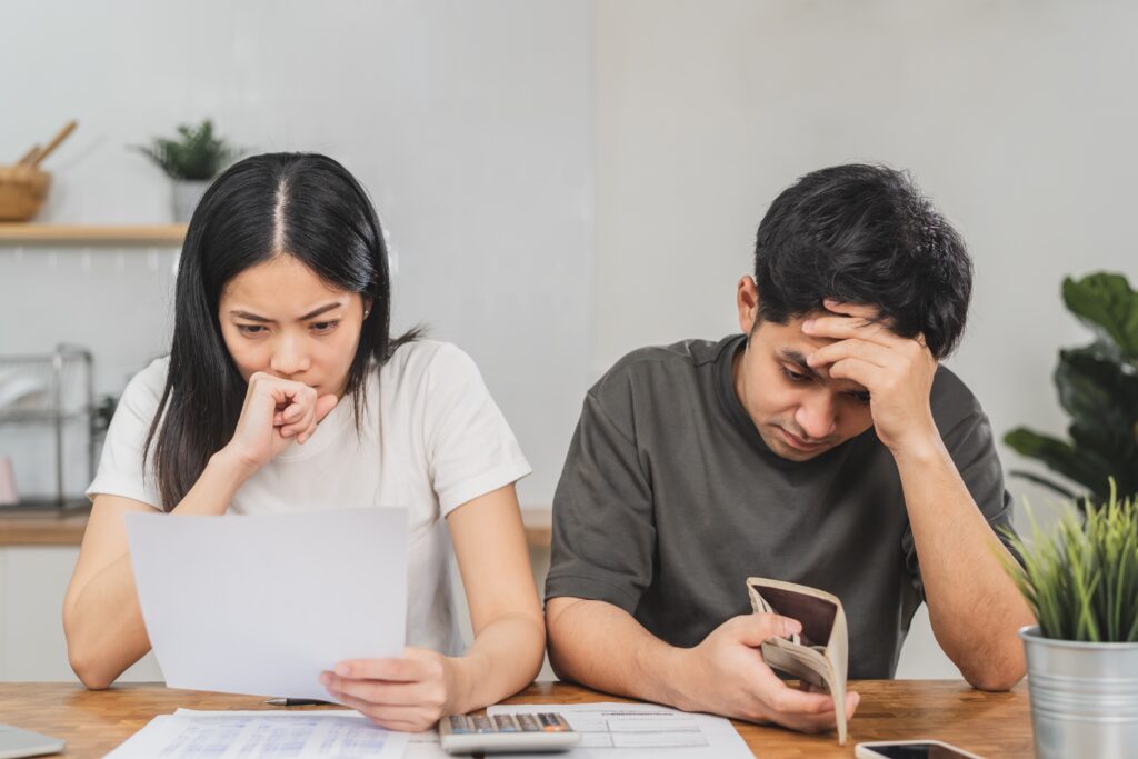Couple looking at their finances at the table, stressed