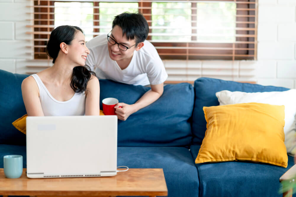 5-creative-ways-work-home-your-spouse-during-pandemic-happy-asian-couple-laptop