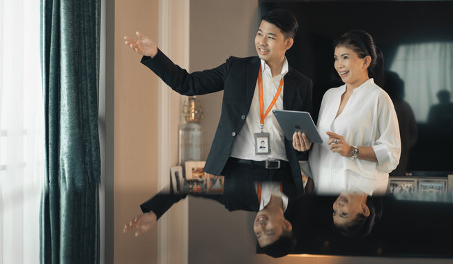 An asian property agent conducting a home viewing with an asian woman