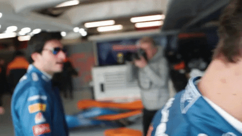 GIF of F1 driver Carlo Sainz running his hands through his hair