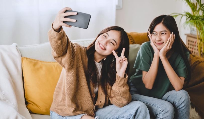 Two girls taking a selfie on the couch