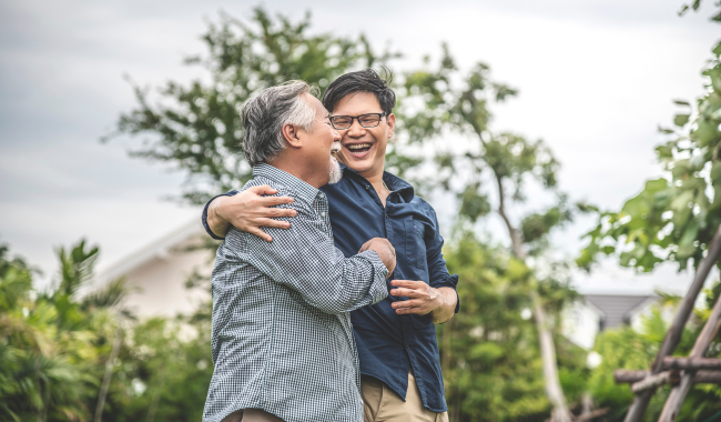 Asian father and son hugging