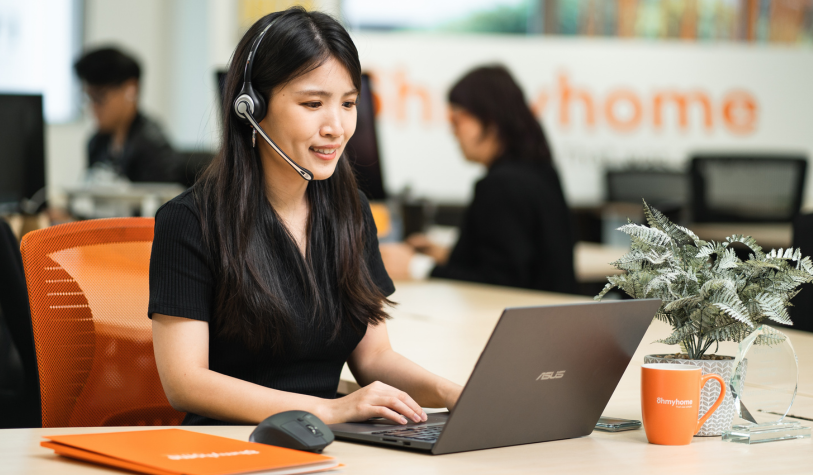 Asian customer service with headset on her laptop